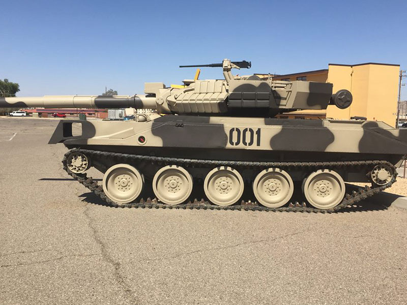 Army tank outside on pavement outside museum.